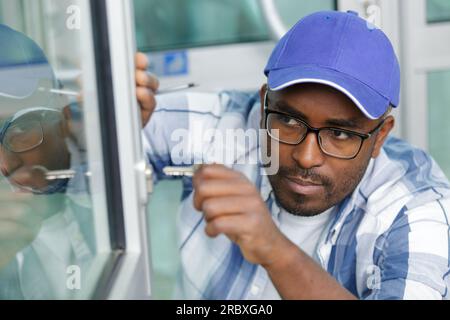 homme verrouillant ou ouvrant une fenêtre à double vitrage Banque D'Images