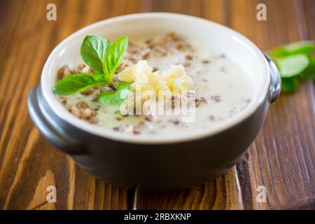 sarrasin bouilli avec lait et beurre pour le petit déjeuner, dans un bol sur une table en bois. Banque D'Images