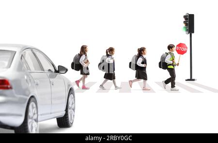 Photo de profil en longueur d'un groupe d'enfants traversant une rue et portant un panneau de signalisation d'arrêt devant une voiture isolée sur fond blanc Banque D'Images