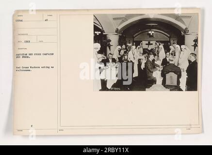 Les travailleurs de la Croix-Rouge servant comme serveuses pendant la campagne de la Croix-Rouge américaine pour des fonds. Cette photographie, numérotée 11244, a été prise en 1919 et reçue par le photographe. L’image montre une scène de l’événement Syndol, où les employés de la Croix-Rouge américaine participent énergiquement à cette collecte de fonds. Banque D'Images