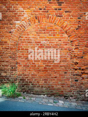 Une arche de porte en briques sur le côté d'un ancien bâtiment d'usine. Banque D'Images