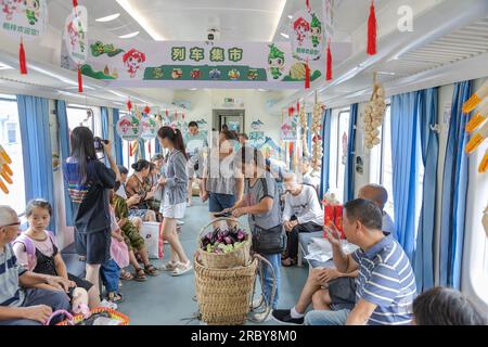 (230711) -- CHONGQING, 11 juillet 2023 (Xinhua) -- des passagers achètent des spécialités locales à bord du train n° 5630 de Zunyi, dans la province du Guizhou, dans le sud-ouest de la Chine, à la municipalité de Chongqing, dans le sud-ouest de la Chine, le 11 juillet 2023. Les trains n ° 5630 et 5629 sont des «trains lents» circulant entre Zunyi de la province de Guizhou et la municipalité de Chongqing dans le sud-ouest de la Chine. Les autorités ferroviaires locales ont organisé des marchés et des spectacles à bord, qui permettent aux villageois vivant le long de l'itinéraire des trains de vendre des marchandises aux passagers et, parallèlement, d'offrir aux passagers une expérience de voyage spéciale. (Xinhua/Huang Wei) Banque D'Images