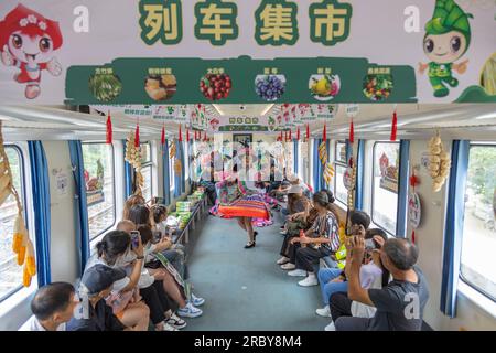 (230711) -- CHONGQING, 11 juillet 2023 (Xinhua) -- des membres du personnel dansent sur le train n° 5630 de Zunyi, dans la province du Guizhou, dans le sud-ouest de la Chine, à la municipalité de Chongqing, dans le sud-ouest de la Chine, le 11 juillet 2023. Les trains n ° 5630 et 5629 sont des «trains lents» circulant entre Zunyi de la province de Guizhou et la municipalité de Chongqing dans le sud-ouest de la Chine. Les autorités ferroviaires locales ont organisé des marchés et des spectacles à bord, qui permettent aux villageois vivant le long de l'itinéraire des trains de vendre des marchandises aux passagers et, parallèlement, d'offrir aux passagers une expérience de voyage spéciale. (Xinhua/Huang Wei) Banque D'Images