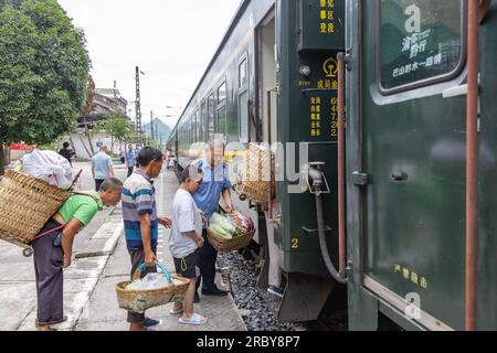 (230711) -- CHONGQING, 11 juillet 2023 (Xinhua) -- un membre du personnel aide les villageois locaux à monter à bord du train n° 5630 de Zunyi, dans la province du Guizhou, dans le sud-ouest de la Chine, à rejoindre la municipalité de Chongqing, dans le sud-ouest de la Chine, le 11 juillet 2023. Les trains n ° 5630 et 5629 sont des «trains lents» circulant entre Zunyi de la province de Guizhou et la municipalité de Chongqing dans le sud-ouest de la Chine. Les autorités ferroviaires locales ont organisé des marchés et des spectacles à bord, qui permettent aux villageois vivant le long de l'itinéraire des trains de vendre des marchandises aux passagers et, parallèlement, d'offrir aux passagers une expérience de voyage spéciale. (Xinhua/Huang Wei) Banque D'Images