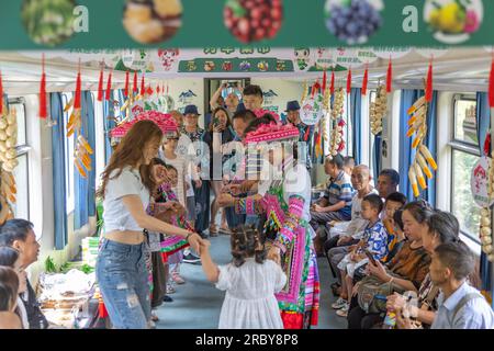 (230711) -- CHONGQING, 11 juillet 2023 (Xinhua) -- des membres du personnel dansent avec des passagers sur le train n° 5630 de Zunyi, dans la province du Guizhou, dans le sud-ouest de la Chine, à la municipalité de Chongqing, dans le sud-ouest de la Chine, le 11 juillet 2023. Les trains n ° 5630 et 5629 sont des «trains lents» circulant entre Zunyi de la province de Guizhou et la municipalité de Chongqing dans le sud-ouest de la Chine. Les autorités ferroviaires locales ont organisé des marchés et des spectacles à bord, qui permettent aux villageois vivant le long de l'itinéraire des trains de vendre des marchandises aux passagers et, parallèlement, d'offrir aux passagers une expérience de voyage spéciale. (Xinhua/Huang Wei) Banque D'Images