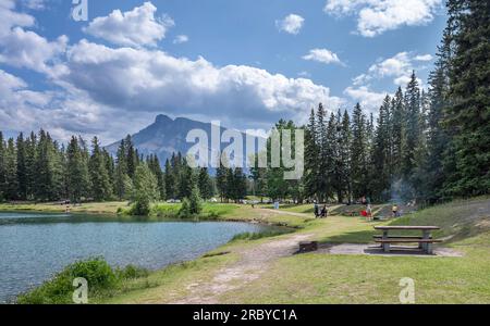 Parc national Banff, Alberta, Canada – le 05 juillet 2023 : les gens se rassemblent à des tables de pique-nique sur la rive de l’étang Cascade Banque D'Images