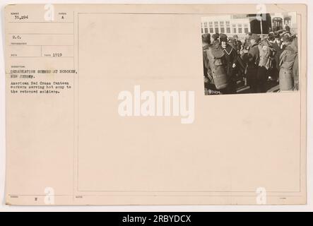 Travailleurs de la Croix-Rouge américaine servant de la soupe chaude aux soldats de retour lors d'une scène de débarquement à Hoboken, New Jersey en 1919. La photographie, numérotée 31 294 S.C., a été prise par un photographe anonyme et reçue dans une collection. L'image représente les efforts humanitaires de la Croix-Rouge américaine pendant la première Guerre mondiale. Banque D'Images