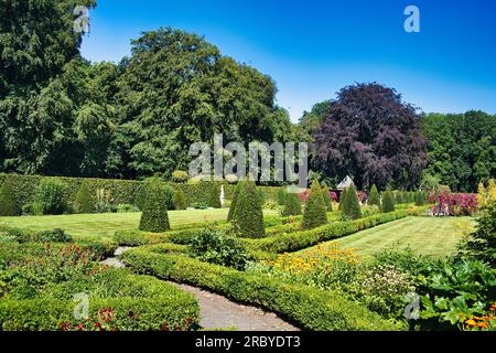 Jardin français formel avec topiaire, parterres de fleurs, haies, pelouses et grands arbres autour du château Menkemaborg, Uithuizen, province de Groningen, pays-Bas Banque D'Images