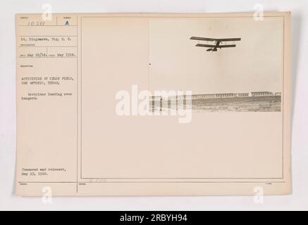 Avion atterrissant au-dessus de hangars à Kelly Field à San Antonio, Texas. Cette photographie, prise en mai 1918, capture les activités sur le terrain pendant la première Guerre mondiale. Le pilote, le lieutenant Kingmore, est vu guider l'avion. L'image est censurée et publiée le 23 mai 1918. Banque D'Images