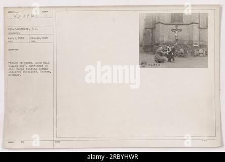 Des soldats américains du 4e corps distribuant du chocolat à des enfants allemands à Cochem, en Allemagne, en signe de bonne volonté pendant la période de l'après-première Guerre mondiale. La photographie a été prise par le sergent S. McAuley le 1 mars 1919. L'image représente le thème de la paix et de la coopération entre les nations. Banque D'Images