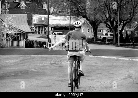 Un homme âgé monte son vélo le long d'une rue de la ville à Abingdon, Virginie, États-Unis Banque D'Images