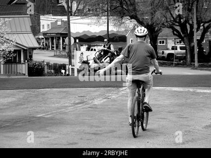 Un homme âgé monte son vélo le long d'une rue de la ville à Abingdon, Virginie, États-Unis Banque D'Images