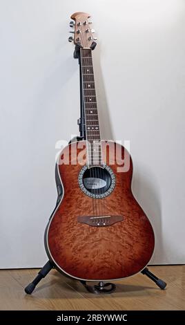 Itterbeck, Allemagne - juin 28 2023 Une guitare acoustique Maple Celebrity Burled d'Ovation sur un support de guitare Banque D'Images