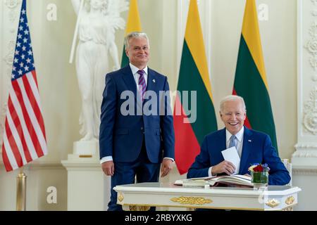 Vilnius, Lituanie. 11 juillet 2023. Le président américain Joe Biden, à droite, sourit après avoir signé le livre d'or alors que le président lituanien Gitanas Nauseda, à gauche, regarde lors d'une cérémonie officielle de bienvenue au Palais présidentiel, le 11 juillet 2023 à Vilnius, en Lituanie. Biden rencontre Nauseda avant le début du sommet de l'OTAN. Crédit : Adam Schultz/White House photo/Alamy Live News Banque D'Images