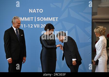 Le président français Emmanuel Macron et son épouse Brigitte Macron (à droite) sont accueillis par le président lituanien Gitanas Nauseda et son épouse Diana Nausediene pour le dîner social du sommet de l'OTAN à Vilnius, en Lituanie. Date de la photo : mardi 11 juillet 2023. Banque D'Images