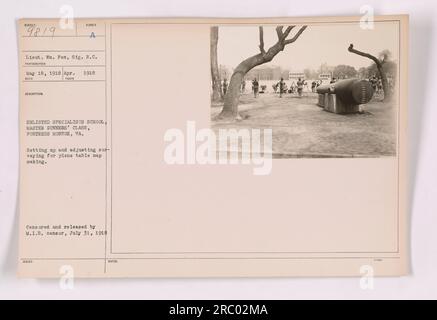 Des spécialistes enrôlés à la classe des maîtres artilleurs à Fortress Monroe, en Virginie, sont vus mettre en place et ajuster l'équipement d'arpentage pour la création de cartes de table d'avion pendant la première Guerre mondiale. Cette photographie a été prise le 18 mai 1918 et a été censurée et publiée par le censeur du M.I.B. le 31 juillet 1918. Banque D'Images