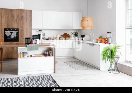 Intérieur de la cuisine légère avec des appareils modernes sur la table en bois Banque D'Images