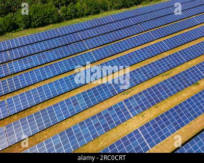 Centrale solaire avec des rangées de panneaux photovoltaïques sur un champ agricole au soleil, Allemagne Banque D'Images