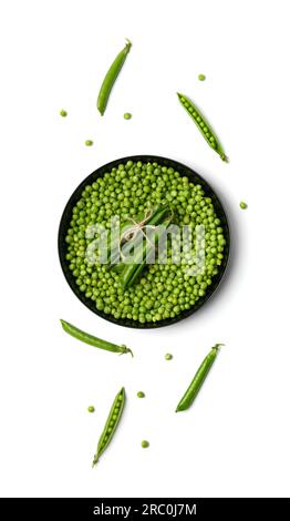 Grains pelés de pois verts frais dans une assiette noire ronde et gousses de pois verts sur fond blanc, vue de dessus. Protéines végétales, produits sains. Banque D'Images