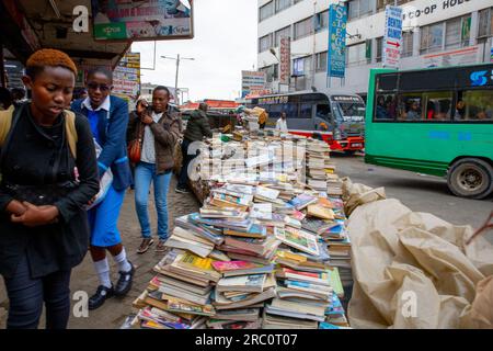 Les piétons passent devant les colporteurs occupés vendant des biens et des services dans les rues du Central Business District (C.B.D) à Nairobi. La vie quotidienne à travers les rues de la ville de Nairobi bien connue comme une ville sous le soleil privée du mot Maasaï Enkare qui se traduit par «lieu des eaux fraîches». Nairobi est la plus grande et capitale du Kenya. Banque D'Images