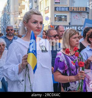 Izmir, Turquie. 11 juillet 2023. Une femme tient un drapeau bosniaque pendant l'événement. Des citoyens bosniaques vivant à Izmir ont organisé une cérémonie commémorative à l’occasion du 28e anniversaire du massacre de Srebrenica. (Photo Murat Kocabas/SOPA Images/Sipa USA) crédit : SIPA USA/Alamy Live News Banque D'Images