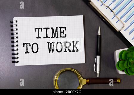 Le temps de travail du texte sur un bloc de bois, couché sur un bloc-notes avec un stylo bleu en métal. Photo de concept d'entreprise Banque D'Images