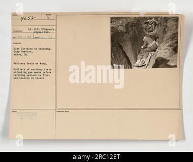 Soldats du train sanitaire de la 31e division suivant un entraînement au masque à gaz au Camp Wheeler à Macon, GA On voit les soldats ajuster leurs masques à gaz avant de transporter un patient au poste de premiers soins situé dans une tranchée. Cette photographie a été prise en février 1918. Banque D'Images