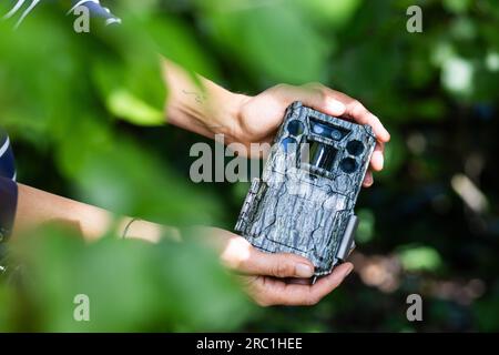 Staufen im Breisgau, Allemagne. 05 juillet 2023. Mara Ziemlich de l'Institut de recherche forestière de Baden-Württemberg (FVA) tient un piège à photo dans sa main. Ziemlich veut l'utiliser pour étudier l'utilisation de biotopes dits de stepping Stone par les animaux sauvages. Il peut s'agir, par exemple, de stations d'épuration, mais aussi de décharges de déchets de construction, qui sont utilisées par les animaux pour un court repos. (À dpa « Animal motel » dans les stations d'épuration - les opérations et la faune vont-elles ensemble ?) Crédit : Philipp von Ditfurth/dpa/Alamy Live News Banque D'Images