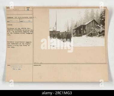 Les soldats de la DIVISION DE PRODUCTION D'ÉPINETTE, Aviation See S.C., hissent le drapeau américain dans un camp militaire de legging sur la RIVIÈRE WISHKAH, Washington. Ces bûcherons et bûcherons expérimentés enrôlés dans le signal corps ont été impliqués dans la production de bois d'épicéa pour les avions militaires pendant la première Guerre mondiale Banque D'Images