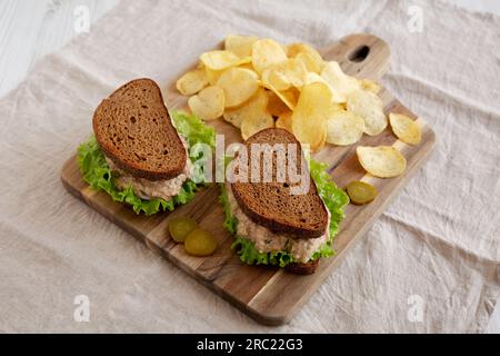 Sandwich au thon maison avec laitue sur une planche de bois, vue latérale. Banque D'Images