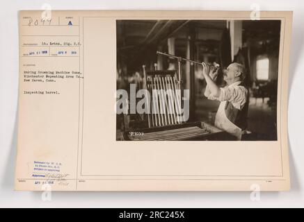 Le lieutenant Letns du signal Reserve corps inspectant un canon tout en fabriquant des mitrailleuses Browning à Winchester Repeating Arms Co., New Haven, Connecticut en avril 1918. Cette photographie a été approuvée et publiée par le Département de la Guerre et obtenue de la Division photo du signal corps. Banque D'Images