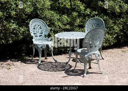 Un ensemble de sièges en fer forgé et table dans un jardin. Banque D'Images