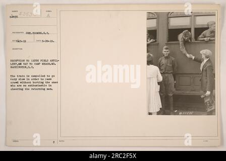 Train transportant le 110th Field Artillery sur leur chemin vers Camp Meade, Maryland, en passant par Washington DC Une grande foule de supporters enthousiastes s'est réunie pour encourager et accueillir les hommes de retour. Le train doit avancer à une vitesse lente pour assurer la sécurité de la foule en acclamation. Photographe : S.C. Coombs. Prise le 28 mai 1919. Numéro d'image 52035.(notes de documentation : symbole de la photo émis : REC665-19, symbole de description : 053835, 3-400). Banque D'Images