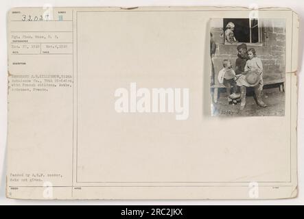 Sergent J.W. Killigrow de la 311e Ambulance Co., 78e Division, est vu sur cette photographie avec des enfants français à Authe, Ardennes, France. La date de la photo n'est pas fournie, mais elle a été approuvée par le censeur de l'A.E.F. Le photographe est le sergent Charles Mace, et la photo porte le numéro 32027. Banque D'Images