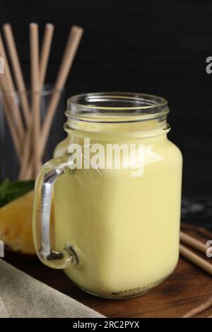Savoureux smoothie à l'ananas dans un pot Mason sur la table, gros plan Banque D'Images