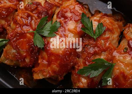 Délicieux petits pains de chou farcis cuits avec de la sauce tomate dans un plat allant au four, vue de dessus Banque D'Images