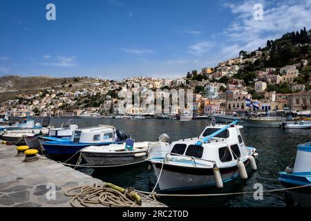 Symi, Grèce - 30 mai 2023 : vue sur la baie du port de l'île de Symi, avec ses petits bateaux colorés et son architecture grecque traditionnelle. Banque D'Images