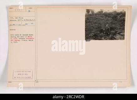 Soldat examinant les dommages causés par les bombes allemandes lors d'un raid aérien à Royaumeix et Sansey, France. La photo montre le soldat 1st Class Rob M. Barnes inspectant un trou laissé par les bombes. Prise le 7 mars 1918, l'image a été publiée par la Division des collèges de guerre et porte le numéro de référence 111-SC-8397. Banque D'Images