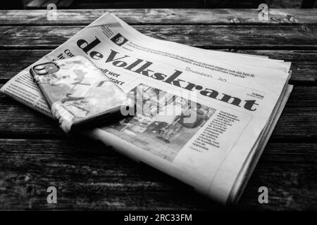 Journal de Volkskrant sur une table de terrasse de plage lu par l'un des invités. Tilburg, pays-Bas. Banque D'Images