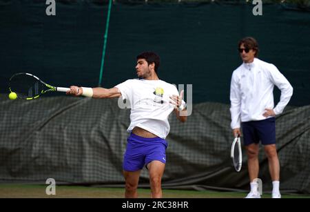 Carlos Alcaraz en action sur les terrains d'entraînement, sous l'œil vigilant de son entraîneur Juan Carlos Ferrero (à droite) lors de la dixième journée des Championnats de Wimbledon 2023 au All England Lawn tennis and Croquet Club à Wimbledon. Date de la photo : mercredi 12 juillet 2023. Banque D'Images