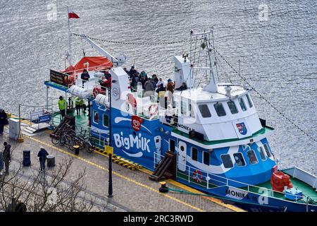 Kolberg, Pologne, 20 avril 2023 : le bateau de plaisance Monoka III avec des touristes embarquant pour une balade, dans le port de la ville polonaise de Kołobrzeg Banque D'Images