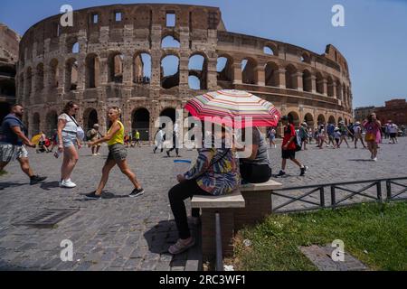 Rome, Italie. 12 juillet 2023 les touristes au colosse romain abritent sous un parapluie du soleil chaud alors que Rome connaît des températures élevées. Le ministère italien de la Santé a émis une alerte rouge alerte canicule pour huit grandes villes en Italie car les températures devraient basculer au-dessus de 40°C/104F. Crédit amer ghazzal/Alamy Live News Banque D'Images