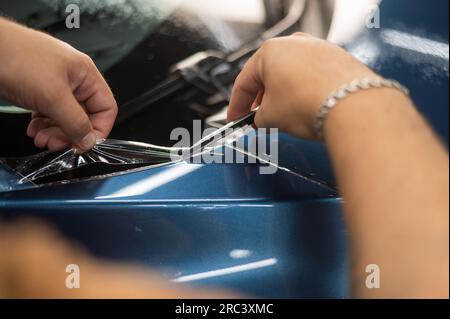 Le maître de service de la voiture coupe le couteau de protection. Banque D'Images