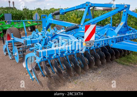 Herse à disques pour le travail du sol dans les zones avec les restes de hautes tiges de maïs et de tournesol sur le matériel et la base technique de l'enterpri agricole Banque D'Images