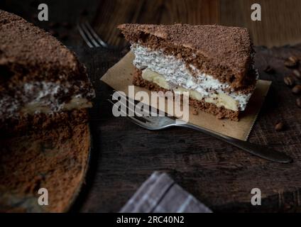 Gâteau tiramisu avec des bananes sur un fond en bois. Banque D'Images