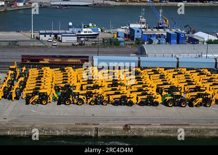 Locomotive de fret diesel-électrique EWS de classe 66 no 66083 en direction d'un train porte-voitures sur les quais de Southampton, avec des JCB jaunes alignés sur le quai. Banque D'Images