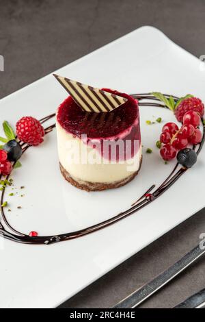 Mini gâteau aux fruits de la forêt sur une assiette en porcelaine blanche Banque D'Images