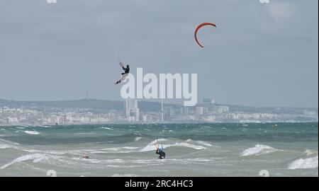 Brighton Royaume-Uni 12 juillet 2023 - les kitesurfers profitent des conditions aérées au large de la plage de Lancing, près de Brighton, que l'on peut voir au loin alors que le temps instable devrait se répandre à travers la Grande-Bretagne dans les prochains jours : Credit Simon Dack / Alamy Live News Banque D'Images