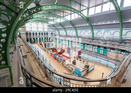 Birmingham, Royaume-Uni. 12 juillet 2023. Une piscine datant de 1907 abrite une transformation temporaire en espace salon. Le Balsall Heath Gala Pool, dans le centre-ville Balsall Heath, Birmingham, a des œuvres d'art, des tapis et des meubles doux placés comme un endroit de bienvenue pour profiter d'une tasse et une discussion. Les bains de Moseley Road sont en cours de rénovation en même temps pour montrer ses accessoires édouardiens. Crédit : Peter Lopeman/Alamy Live News Banque D'Images