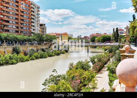 Vue sur la passerelle en béton Miguel Caballero à travers la rivière Segura dans le centre de la ville de Murcie à la journée ensoleillée d'été contre l'architecture et le cl bleu Banque D'Images